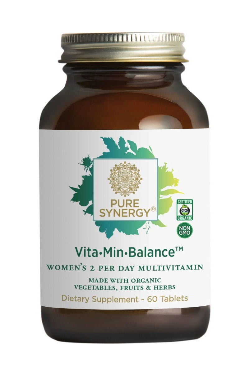 A brown glass bottle of The Synergy Company Vita•Min•Balance® For Women contains 60 tablets with organic vegetables, fruits, herbs, and adaptogen extracts. The label has “Non-GMO” and “USDA Organic” logos.