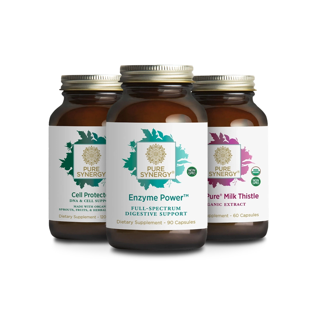 Three amber glass bottles of Pure Synergy supplements are displayed. The labels indicate they are Cell Protector, Enzyme Power, and Pure Milk Thistle, each providing different health benefits. The bottles are arranged in a triangular formation.