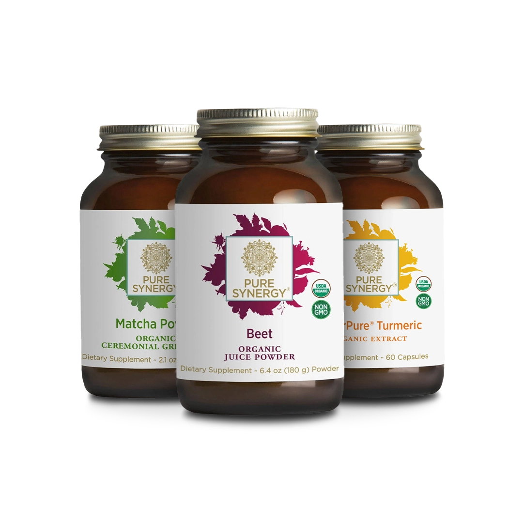Three brown jars of Pure Synergy dietary supplements. Labels show Organic Matcha, Beet Juice Powder, and Pure Turmeric. Each jar features a colorful botanical design and USDA organic certification seal.