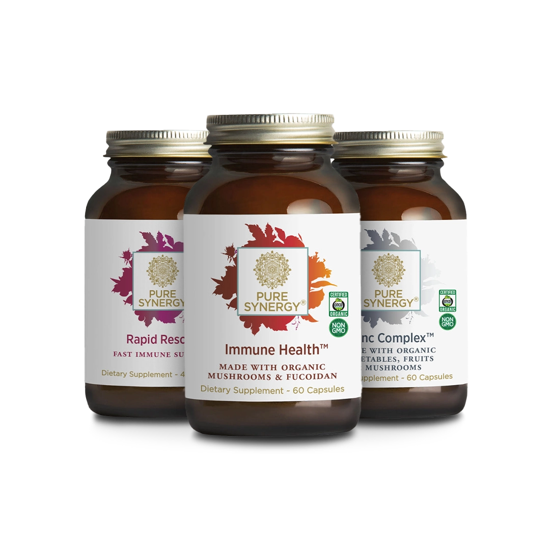 Three brown glass bottles with gold lids labeled Pure Synergy. The labels indicate dietary supplements: Rapid Rescue, Immune Health, and Zinc Complex, each with distinct colorful designs.