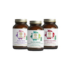 Three brown glass bottles from The Synergy Company’s You Glow Girl Bundle, featuring Radiant Mood, Vita·Min·Balance women’s multivitamin, and SuperPure Astaxanthin with colorful leaf designs on white labels, displayed on a white background.