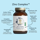 A brown glass bottle of The Synergy Company Zinc Complex™ is centered on a blue background, with labeled arrows pointing to features such as immune support, aluminum lid, organic mushroom mycelia, sustainable production, and fermented zinc.